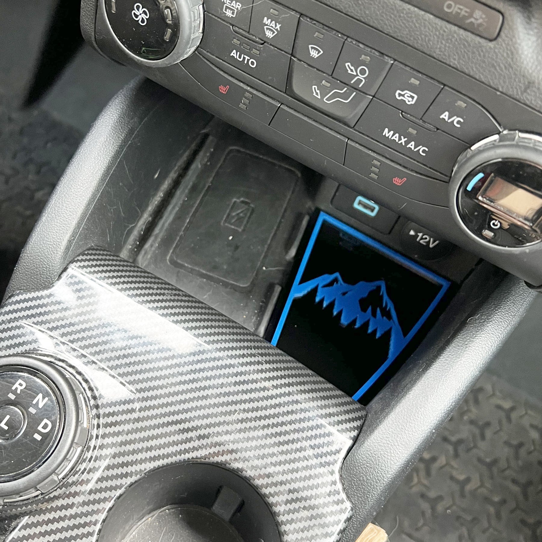 Inserto de bolsillo de almacenamiento de consola inferior con emblema de montaña. Compatible con Bronco® Sport 2021+. Disponible en varios colores