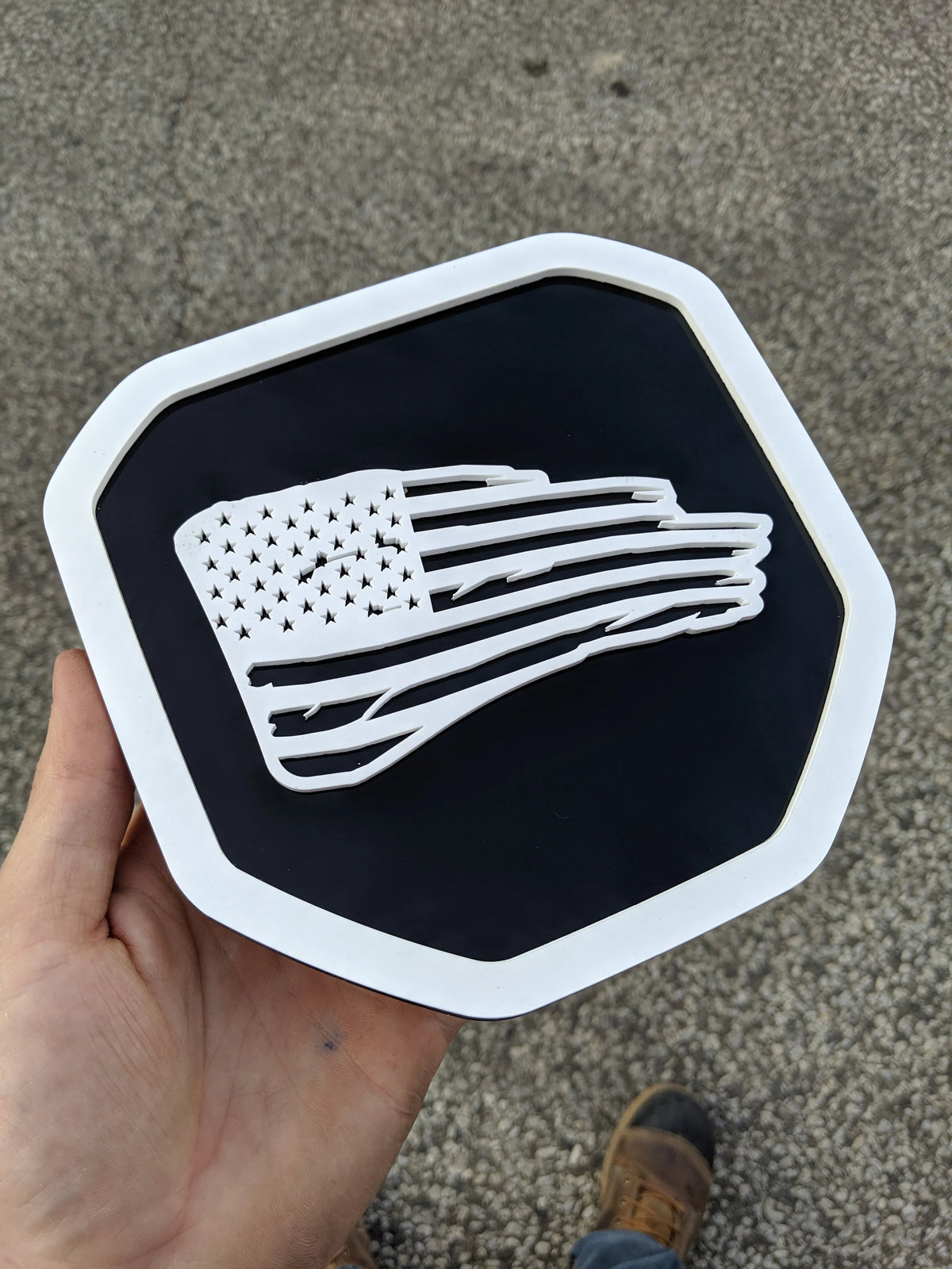 Insignia de la bandera estadounidense hecha jirones. Compatible con Dodge® Ram® 2019+ (quinta generación): 1500, 2500, 3500. Blanco sobre negro.