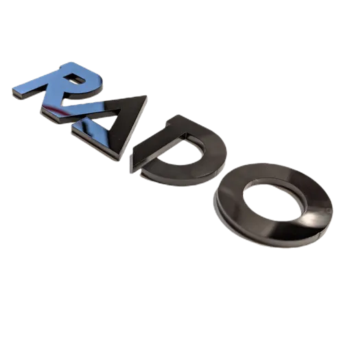 Insignia Rado - Letra en negrita - Una capa - Negro - Par