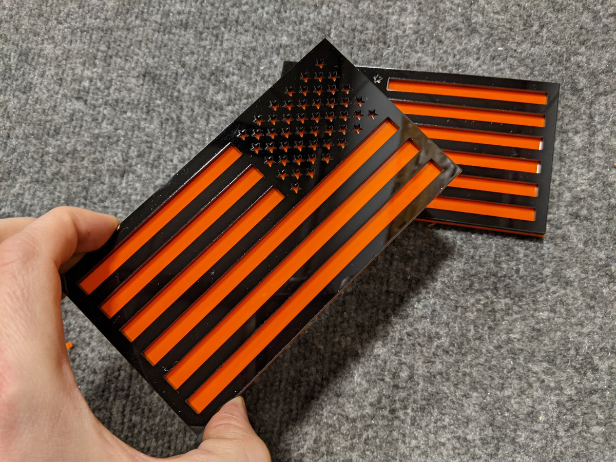 Insignias para guardabarros con la bandera estadounidense (par), ajuste universal, color negro sobre naranja