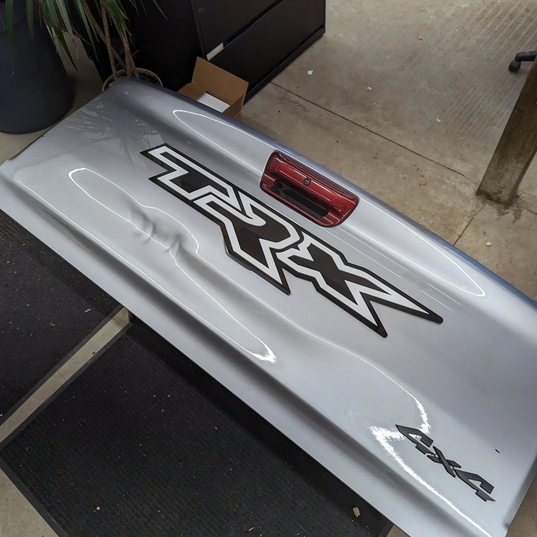 Insignia para portón trasero XL TRX - Montaje con cinta adhesiva - Varios colores disponibles - Producto con licencia oficial