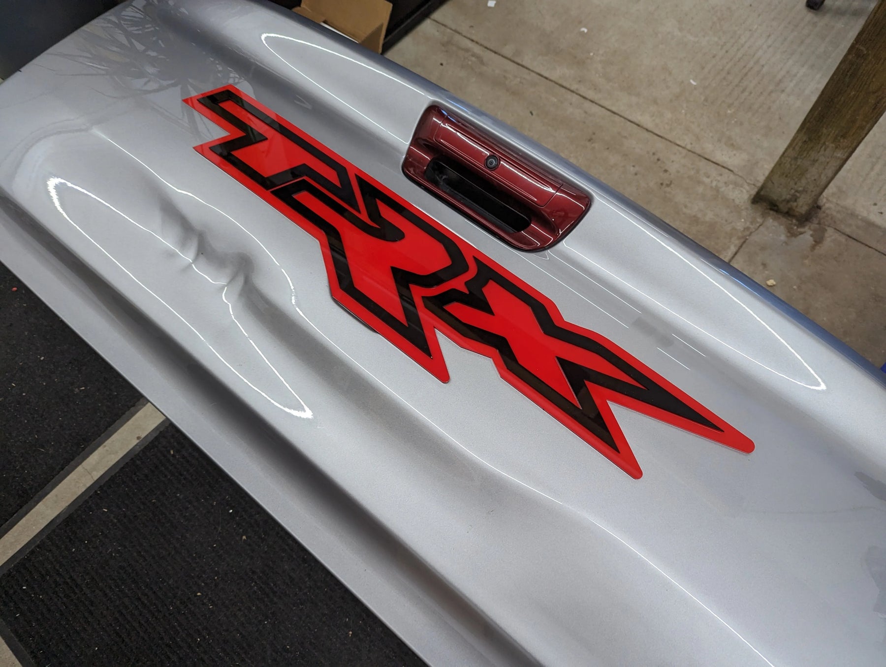 Insignia para portón trasero XL TRX - Montaje con cinta adhesiva - Varios colores disponibles - Producto con licencia oficial