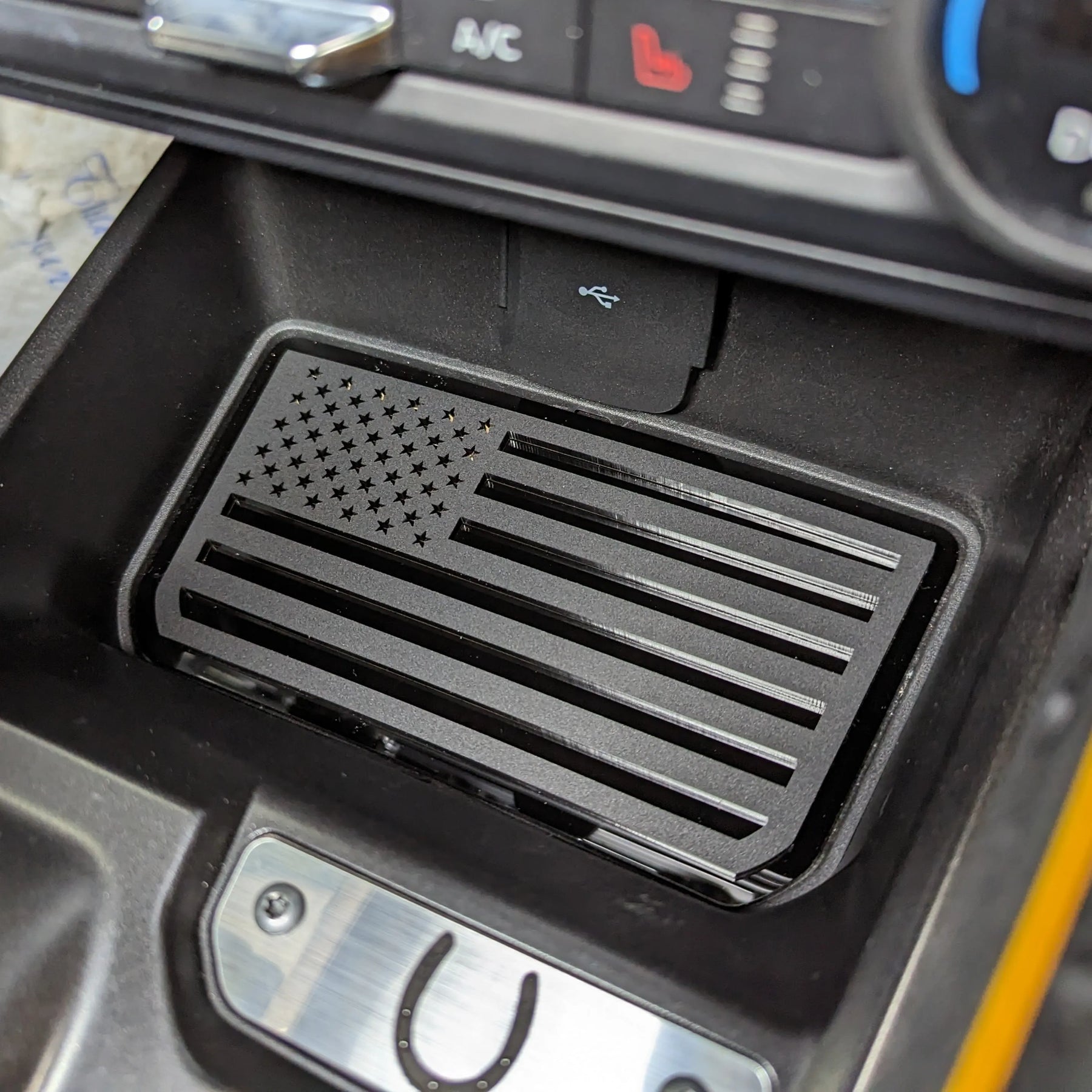 Bolsillo de almacenamiento de consola con emblema de bandera estadounidense. Compatible con Bronco® 2021+ (automático). Disponible en varios colores