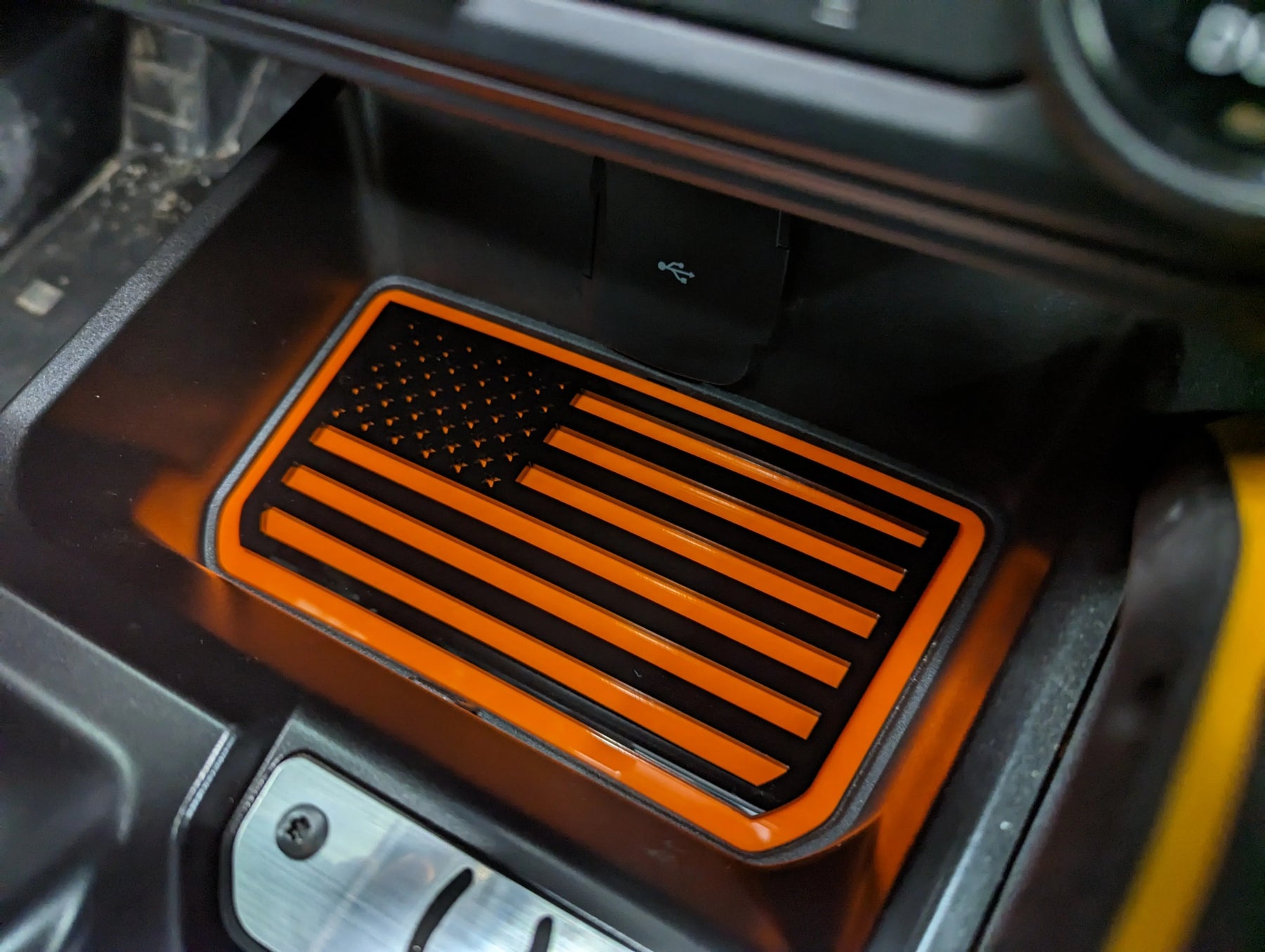 Bolsillo de almacenamiento de consola con emblema de bandera estadounidense. Compatible con Bronco® 2021+ (automático). Disponible en varios colores